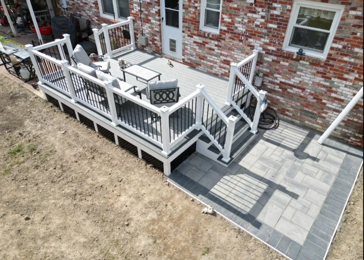 Compact composite deck with angled stairs and dining area in a small backyard